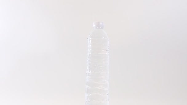 Sluit Een Plastic Fles Drinkwater Stil Water Draaien Witte Achtergrond — Stockvideo