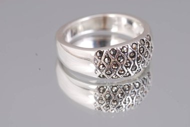 Yansıtıcı arka planda izole edilmiş güzel gümüş bir yüzük.