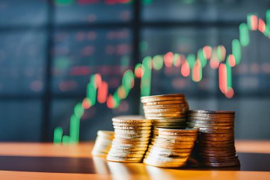 ... üzerinde ahşap dolaplar, üzerinde buzdolabı, para ve borsa grafiği olan modern, uzun düz, koyu yeşil bir mutfak.