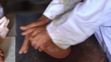 Meşhur ve tipik Granada çömlekçiliğinin geleneksel fabrikası Fajalauza 'da bir parça kil yoğuran bir zanaatkar. Sanatçılık kavramı.