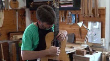İspanyol gitarcı, ya da Luthier, sesini test etmek için flamenko gitar çalıyor. İspanya, Endülüs ve Granada 'da zanaat ve flamenko kavramı.