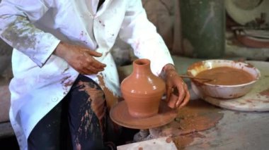 Granada 'nın ünlü ve tipik çömlekçiliğinin geleneksel bir fabrikası olan Fajalauza' da Arap çömlekçi çarkında bir çömlek kalıbı döşeyen bir zanaatkâr. Sanatçılık konsepti.