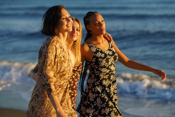 Positive Multiracial Female Friends Hugging Strolling Together Seashore Waving Sea — Stockfoto