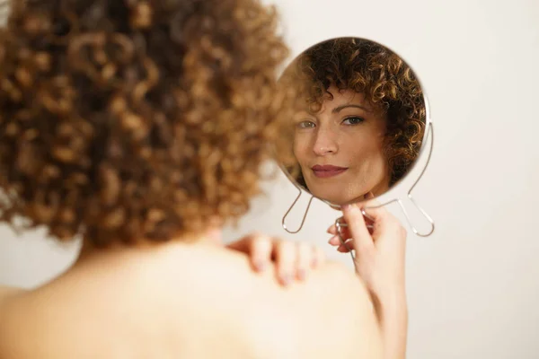 아름다운 곱슬곱슬 머리와 화장을 거울을 배경에 가까운 모습으로 카메라를 바라보면서 — 스톡 사진