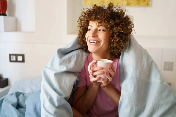 Bir Fincan Sıcak Içecekle Tatmin Olmuş Bir Kadın Sabahları Yatağında — Stok fotoğraf