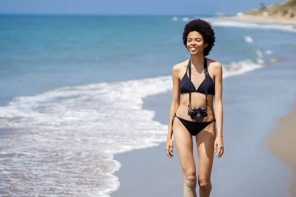 Χαρούμενη Αφρο Αμερικανίδα Τουρίστρια Μπικίνι Φωτογραφική Μηχανή Περπατάει Υγρή Ακτή — Φωτογραφία Αρχείου
