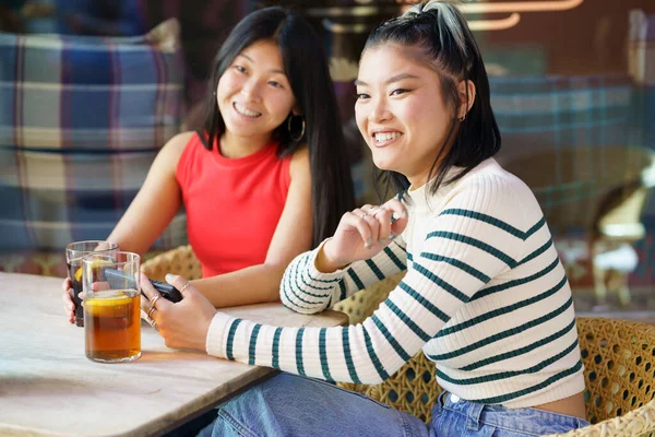 两名年轻的中国妇女在格拉纳达一家典型的酒吧的阳台上喝一杯 亚洲人在欧洲旅行的概念 — 图库照片