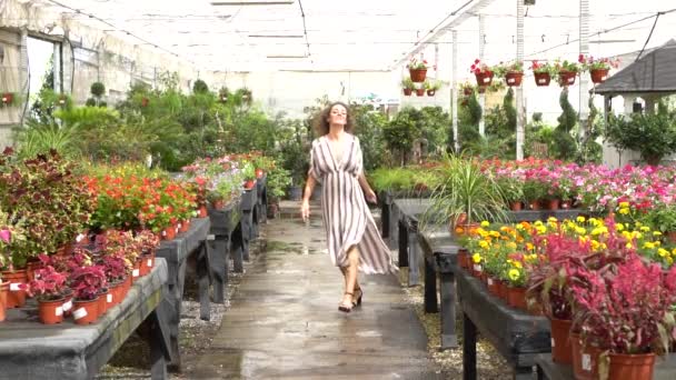 Повільний Рух Усміхненої Молодої Жінки Роздвоєному Платті Насолоджуючись Квітучими Рослинами — стокове відео