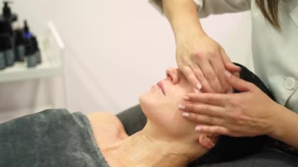 Tempo Real Cosmetologista Feminino Fazendo Massagem Facial Mulher Jovem Deitada — Vídeo de Stock