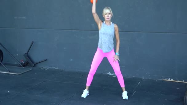 슬로우 휘트니스 센터에서 체중을 올리는 운동을 운동복에 성숙한 스포츠 여성의 — 비디오