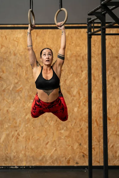 Spor Salonunda Spor Yaparken Olimpiyat Yüzüklerinden Sarkan Bir Kadının Dikey — Stok fotoğraf