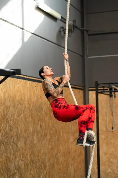 Güçlü Olgun Bir Kadının Spor Salonunda Halata Tırmanırken Çekilmiş Dikey — Stok fotoğraf