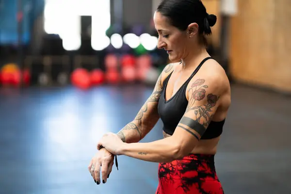 Woman wrapping her wrist to protect it from injured on a gym
