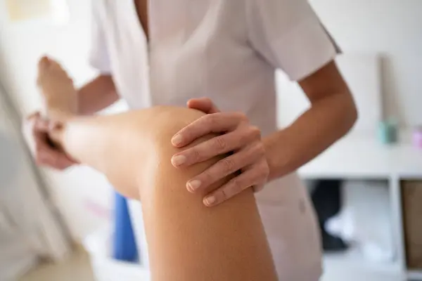 Schnitte Anonyme Weibliche Osteopathin Macht Knie Manipulation Während Physiotherapie Sitzung Stockbild