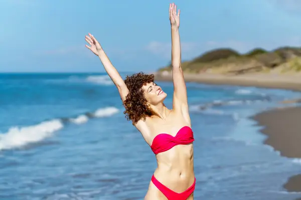 Smiling Young Female Pink Bikini Curly Hair Raising Arms While Royalty Free Stock Photos