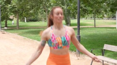 Kararlı ve kendini işine adamış dinamik bir kadın canlı bir açık hava parkında ip atlamakla egzersiz yapıyor. Sağlıklı ve zinde kalmak açık hava aktivitelerine katılmak suretiyle hayati önem taşır.