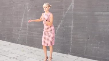 Canlı bir şehirde pembe bir elbiseyle dans eden bir kadın modern bir şehir zeminine karşı hareketini ve ifadesini harmanlıyor. Çağdaş ve dinamik bir duyguyu özgürlük ve zarafetle çağrıştırıyor.