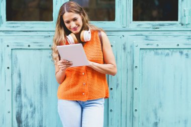 Şehirde tabletle çalışan modern Latin bir kadının ön portresi.