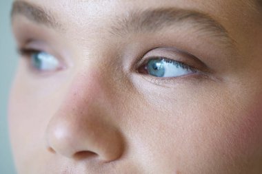 Kafkasyalı zarif bir kadının mavi gözlerinin hiper yakın çekimi yana bakıyor.