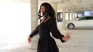 Sokakta dans eden genç siyahi kadın, çok gösterişli kıyafetler giyiyor. Gençlik hayatı ve iyi titreşimler kavramı.