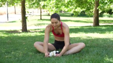 Huzurlu bir parkta, spor kıyafetli bir kadın kelebek yoga pozu vererek dengeyi ve esnekliği geliştiriyor. Bu açık hava yoga seansında huzur ve motivasyon buluyor.