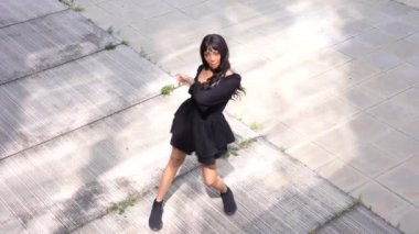 Sokakta dans eden genç siyahi kadın, çok gösterişli kıyafetler giyiyor. Gençlik hayatı ve iyi titreşimler kavramı.