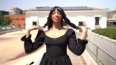 Sokakta dans eden genç siyahi kadın, çok gösterişli kıyafetler giyiyor. Gençlik hayatı ve iyi titreşimler kavramı.