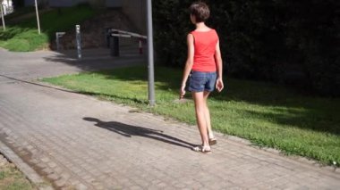 Genç bir kız, neşeli yeşil ve renkli çiçeklerle çevrili, neşeli, kaygısız bir yaz gününün mükemmel özünü yakalıyor. Güneş ışığı ve kahkahalarla dolu.