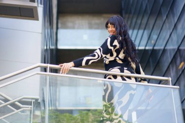 Şehvetli kadın İspanyol dansçı bir binanın kentsel perspektifinden aşağıya bakıyor.