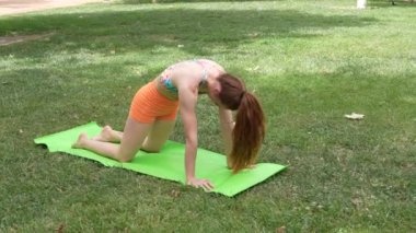Bir kadın açık havada yoga yapıyor, Childs Poose 'dan CatCow' a sorunsuzca geçiş yapıyor. Bu sahne denge ve sükuneti destekleyen sağlık, sağlık ve fitness projeleri için mükemmel.