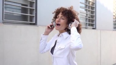 Neşeli ve hareketli bir kadın açık havada konuşurken hareketli hareketler yapar. Etkileyici iletişim tarzını gösterir ve hareketli kişiliğini dinamik tavırlarıyla ifade eder.