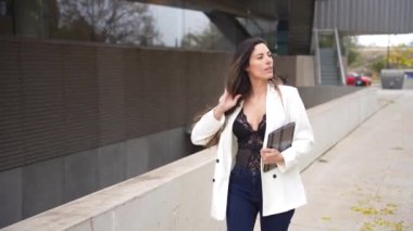 Şık bir kadın canlı ve modern bir şehir ortamında güvenli adımlar atar, zarafet, zarafet ve çağdaş modanın mükemmel bir karışımını sergiler, varlığıyla şehri aydınlatır.