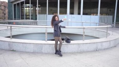 Neşeli genç bir kadın modern korkuluklara karşı neşeli bir selfie çeker, şehir tarzını, canlı kişiliğini ve günümüz dünyasında çağdaş bir birey olarak kendine olan güvenini gösterir.