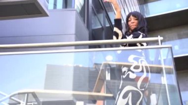 Sokakta dans eden genç siyahi kadın, çok gösterişli kıyafetler giyiyor. Gençlik hayatı ve iyi titreşimler kavramı.