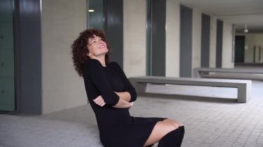 Modayı takip eden bir kadın, modaya uygun bir şehir ortamında elinde akıllı bir telefonla zarif bir şekilde poz vererek modern tarz ve kesme teknolojisinin mükemmel bir karışımını sergiliyor.