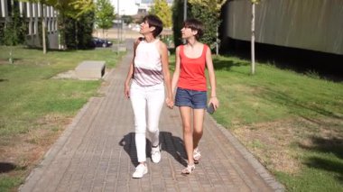 Güneşli güzel bir günde, iki genç kadın birlikte vakit geçiriyorlar, hareketli bir şehir ortamında yan yana yürüyorlar, gerçek dostluğun ve mutluluğun saf özünü somutlaştırıyorlar.