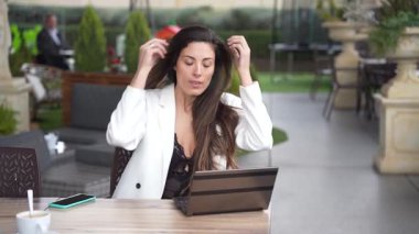 Sakin bir açık hava ortamında, kıtır kıtır beyaz bir ceket giymiş kararlı bir kadın, üretkenliğin gücünü kucaklarken kendine güven ve profesyonellik saçıyor.