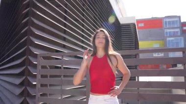 Canlı kırmızı kıyafetli yetenekli bir dansçı kollarını çarpıcı bir zemin üzerine açar, akışkan hareketlerle neşe ve yaratıcılığı somutlaştırır, seyirciyi büyüler ve büyüler içinde bırakır.