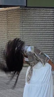 Canlı bir bohem kıyafeti içinde şık bir kadın açık havada duruyor. Bu da onu, bireyselliğini ve eşsiz yeteneğini ön plana çıkaran yaşam tarzı ve moda fotoğrafçılığı için mükemmel bir konu yapıyor.