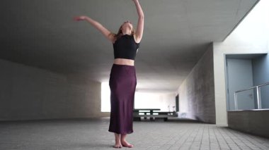 Zarif bir dansçı, minimalist mimari alanda zarif ve akıcı hareketler sergiliyor. Sanat formlarındaki akıcılık ve derin ifadenin özünü güzel bir şekilde vurguluyor.