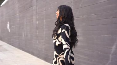 Sokakta dans eden genç siyahi kadın, çok gösterişli kıyafetler giyiyor. Gençlik hayatı ve iyi titreşimler kavramı.