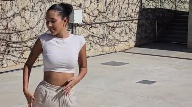 Canlı bir şehir ortamında, yetenekli bir dansçı büyüleyici dans performansı yoluyla zarafetin ve çağdaş tarzın özünü yakalayarak akıcı ve zarif hareketler sergiler.