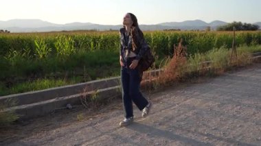 Genç bir kadın dolambaçlı bir yolda yürüyor canlı yeşil tarlalarda ve görkemli dağlarda, sükuneti somutlaştırıyor ve doğayla derin bir bağ kuruyor, yolculuğunda huzur ve neşe aşılıyor.