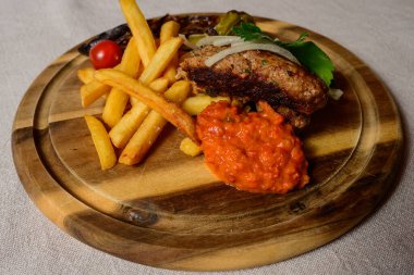 Cevapcici Balkan Style Meatballs with Ajvar Sauce, Onions, Parsley, French Fries and Grilled Pepper clipart