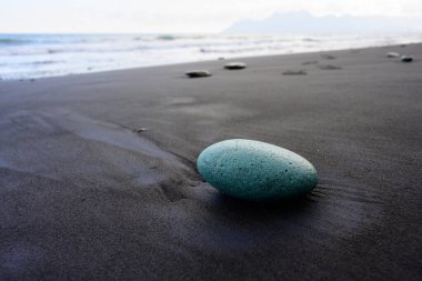 Green Stone on Penggajawa Beach with Black Sand on Flores Island, Indonesia clipart