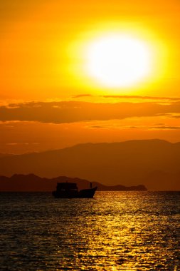 Flores Adası, Endonezya 'da bir teknenin siluetiyle Komodo Ulusal Parkı Günbatımı