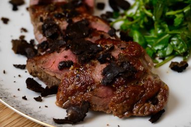 Tagliata di Manzo al Tartufo dilimlenmiş mantarlı biftek yanında da yeşil roket veya Arugula salatası.