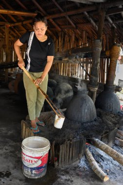 Aimere, Flores, Endonezya - 31 Ekim 2024: Geleneksel Endonezya İçki Fabrikasında Damıtılmış Kadın.