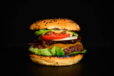 Hamburger veya çizburger Wagyu Burger ızgara biftek Patty, domates, marul, soğan, domuz pastırması ve peynirli peynirli susamlı çörek.