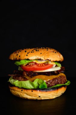 Hamburger veya çizburger Wagyu Burger ızgara biftek Patty, domates, marul, soğan, domuz pastırması ve peynirli peynirli susamlı çörek.